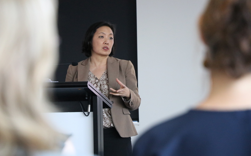 Surie Moon speaking at a podium