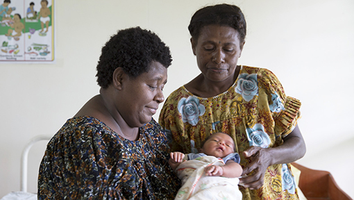 Two women holding a baby